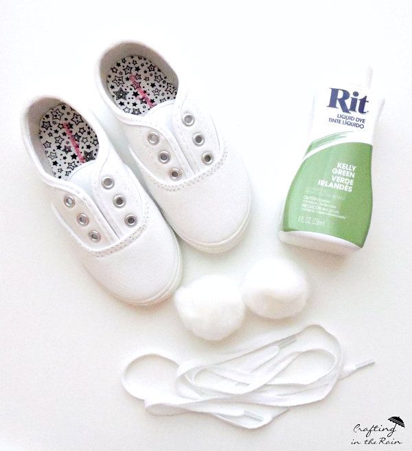 white shoes and accessories laid out on top of a table with the shoe laces still attached