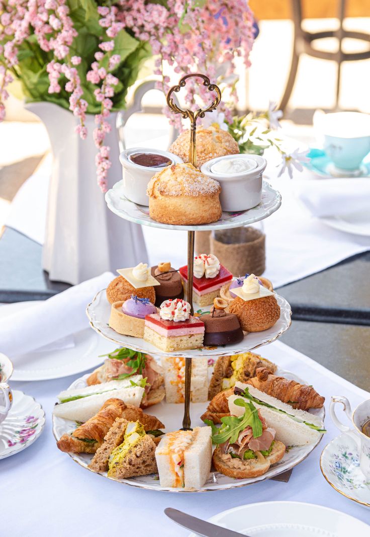 three tiered trays filled with different types of pastries and desserts on top of each other