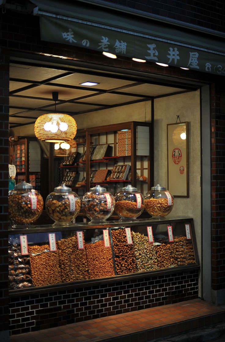 a store front with lots of different items on display in glass bowls and hanging lights