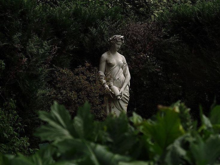 a statue in the middle of some bushes