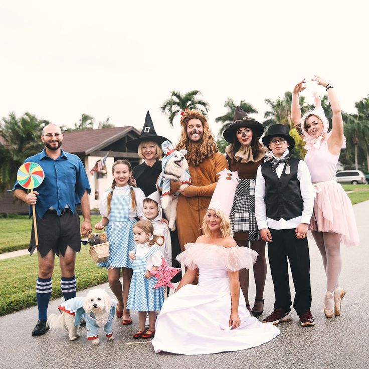 a group of people dressed in costumes posing for a photo with their dogs and children