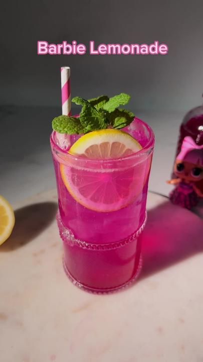 a pink drink with lemon and mint garnish