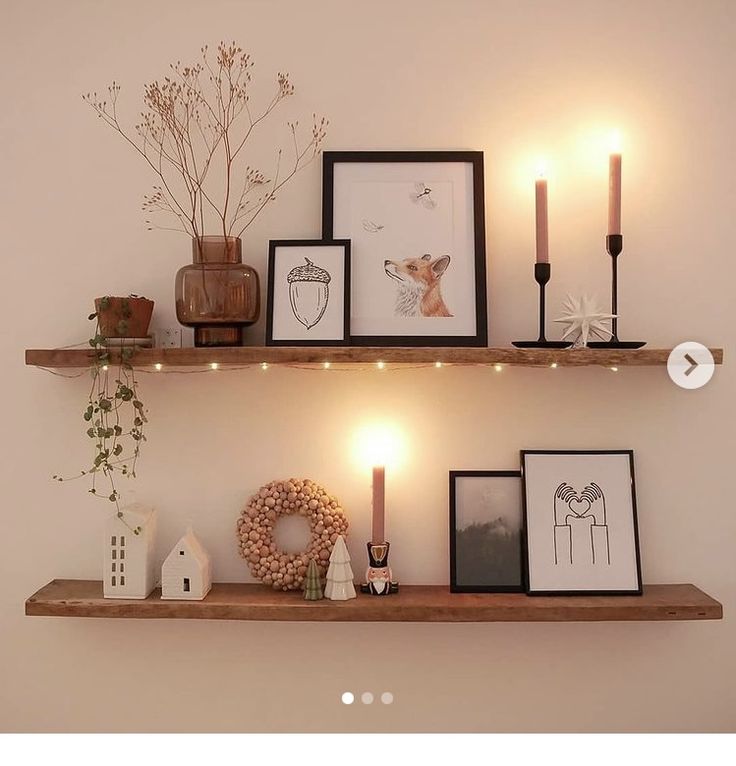 two shelves with pictures and candles on them