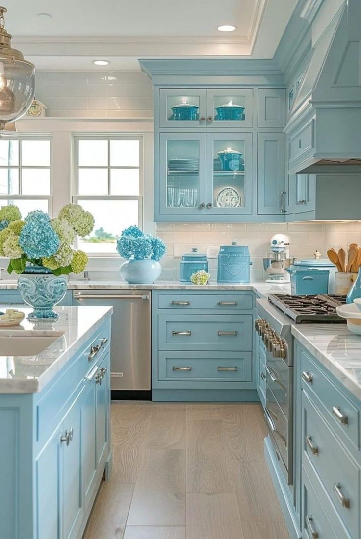 a kitchen filled with lots of blue cabinets and counter top space next to a window