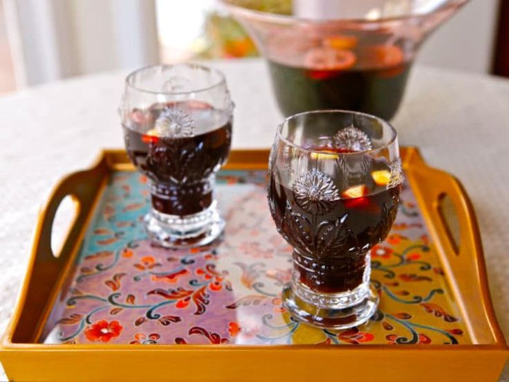 two glasses on a tray with liquid in them