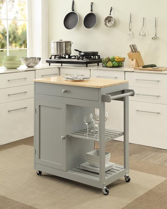 a kitchen island cart with two pans on it in the middle of a room