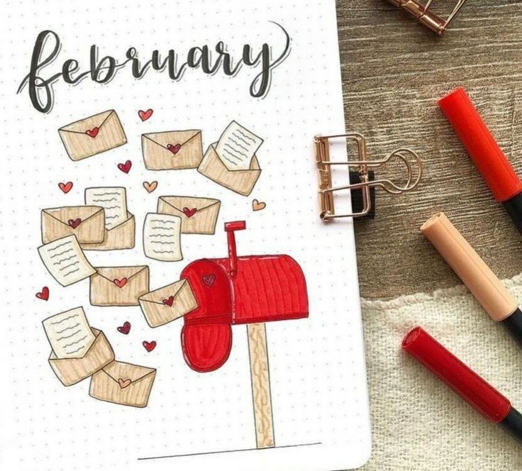 an open notebook with the words february written on it next to some pens and paper clips