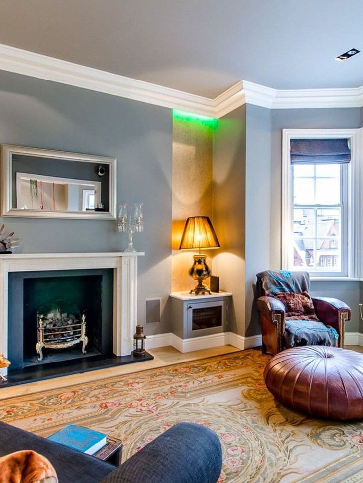 a living room filled with furniture and a fire place under a window next to a fireplace