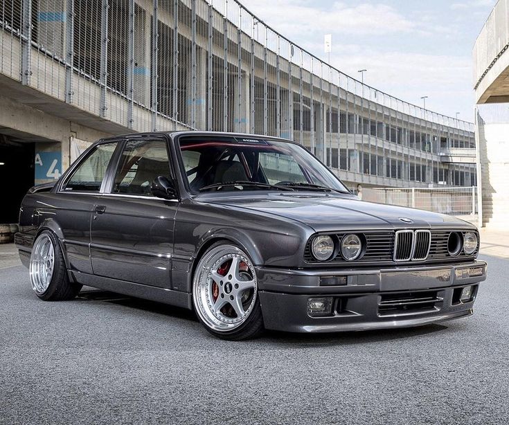 an old bmw is parked in front of a building