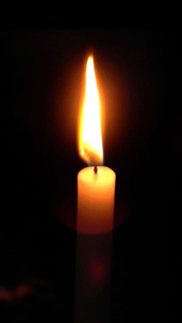 a lit candle is shown in the dark