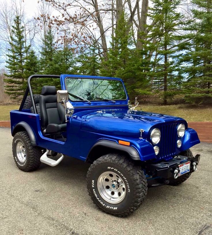 a blue jeep is parked in a parking lot