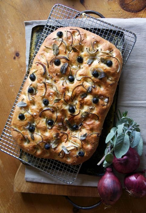 a loaf of bread sitting on top of a cooling rack next to radishes