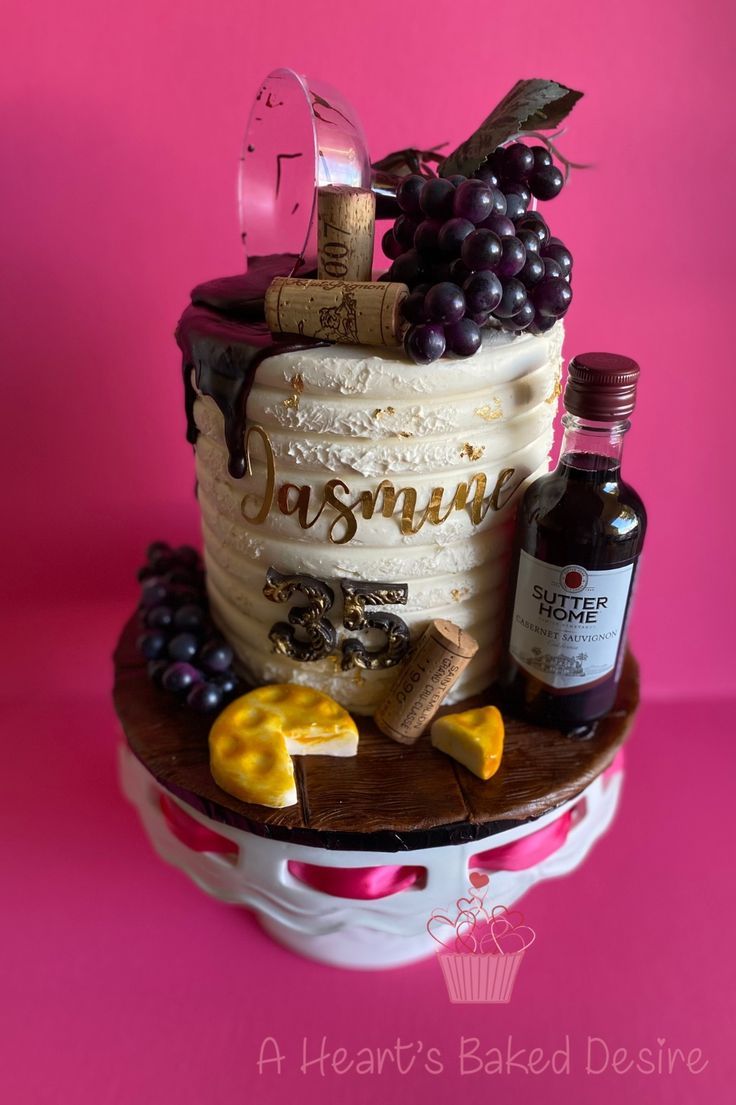 a cake decorated with wine, cheese and grapes