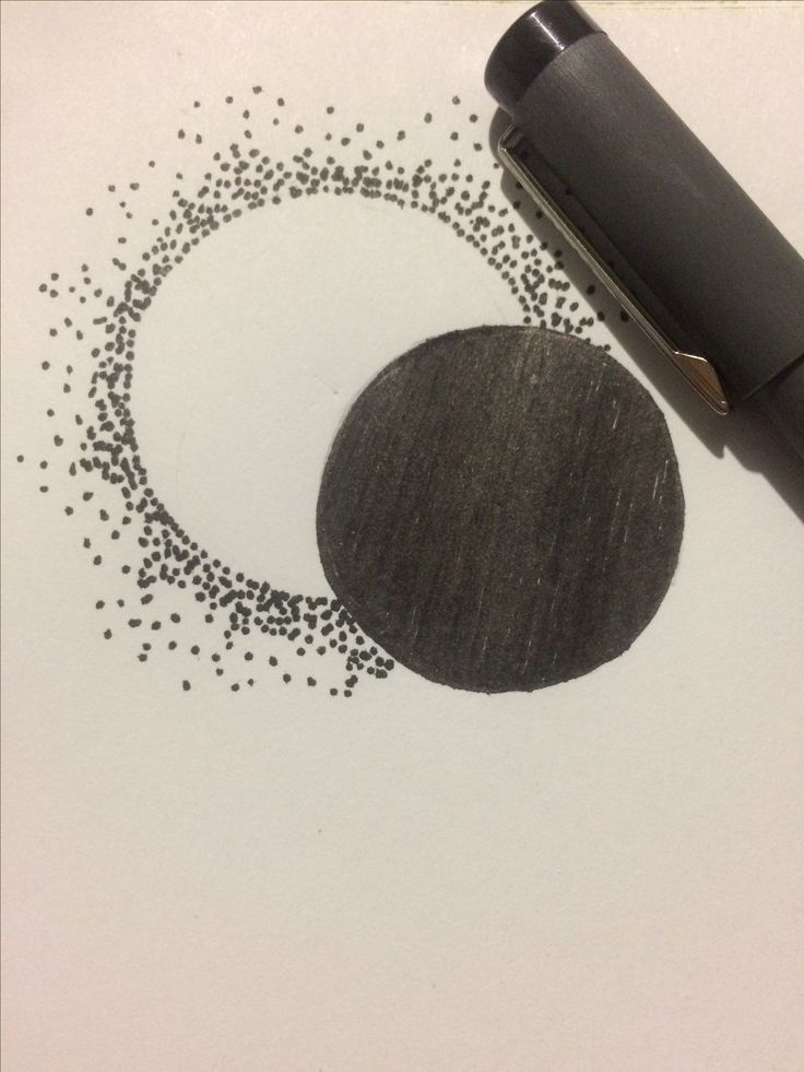 a pen is laying on top of a drawing paper with black dots in the shape of a circle