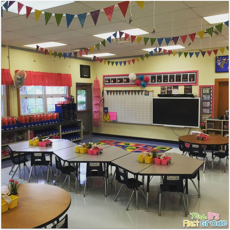 an empty classroom with tables and chairs