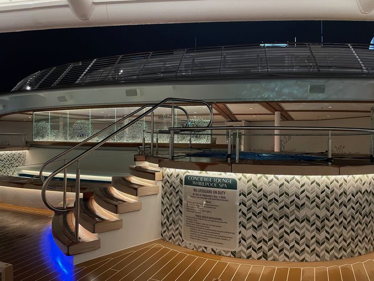 the interior of a cruise ship at night with stairs and railings on both sides