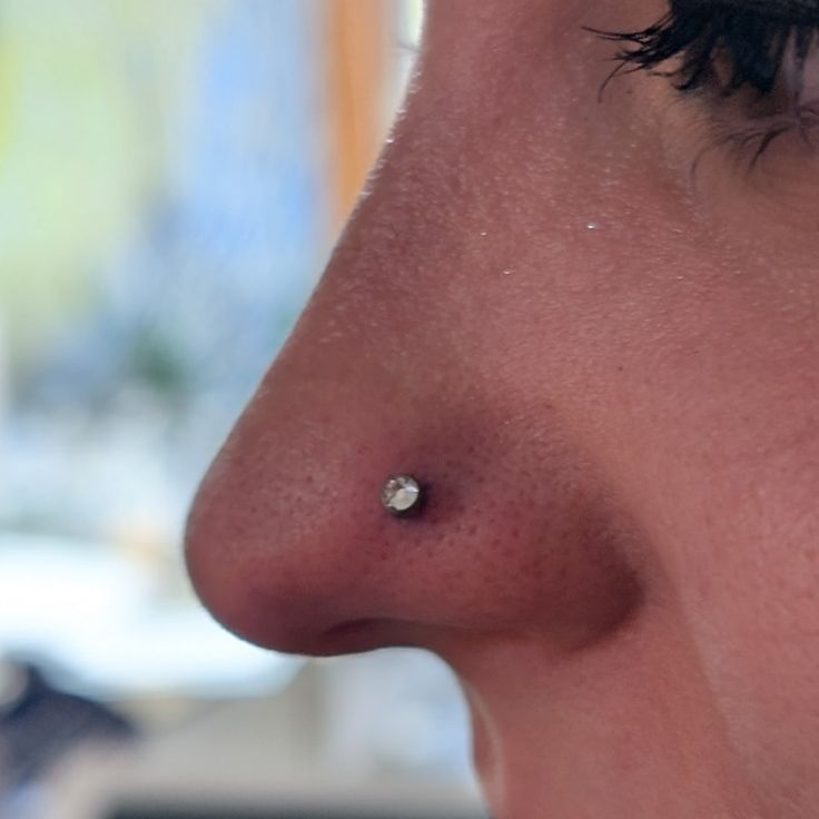 a close up of a person with a nose piercing on it's left side