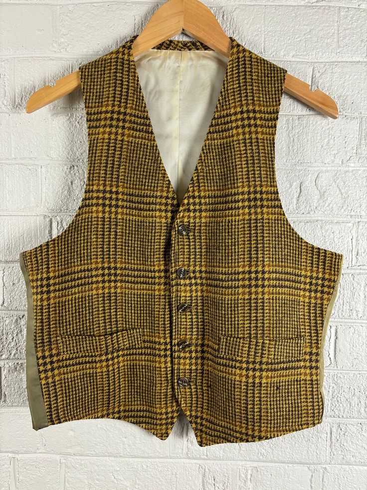 Vintage 1960's Glen Plaid Wool Blend Vest Waist Coat. Men's medium. Brown and Gold Plaid Wool Front with Olive Green Nylon Back and Ivory Inner Lining. In Good Vintage Condition with some Fading on the outer Back Shell and some discoloration on the inner shell. All due to age and sunlight. Vest has two lined pockets on the front. If you have any questions, please don't hesitate to ask!  Thank You Tailored Vintage Cotton Outerwear, Vintage Fall Vest With Buttons, Vintage Fitted Vest For Fall, Vintage Winter Vest With Button Closure, Vintage Beige Vest With Pockets, Beige Vintage Vest With Pockets, Vintage Wool Vest For Fall, Tailored Vintage Fall Vest, Fitted Yellow Vest For Fall