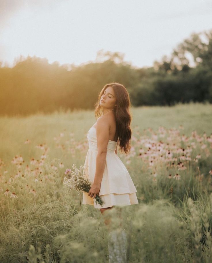 a woman standing in a field with flowers