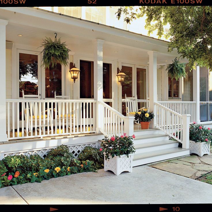 the front porch of a house with potted plants