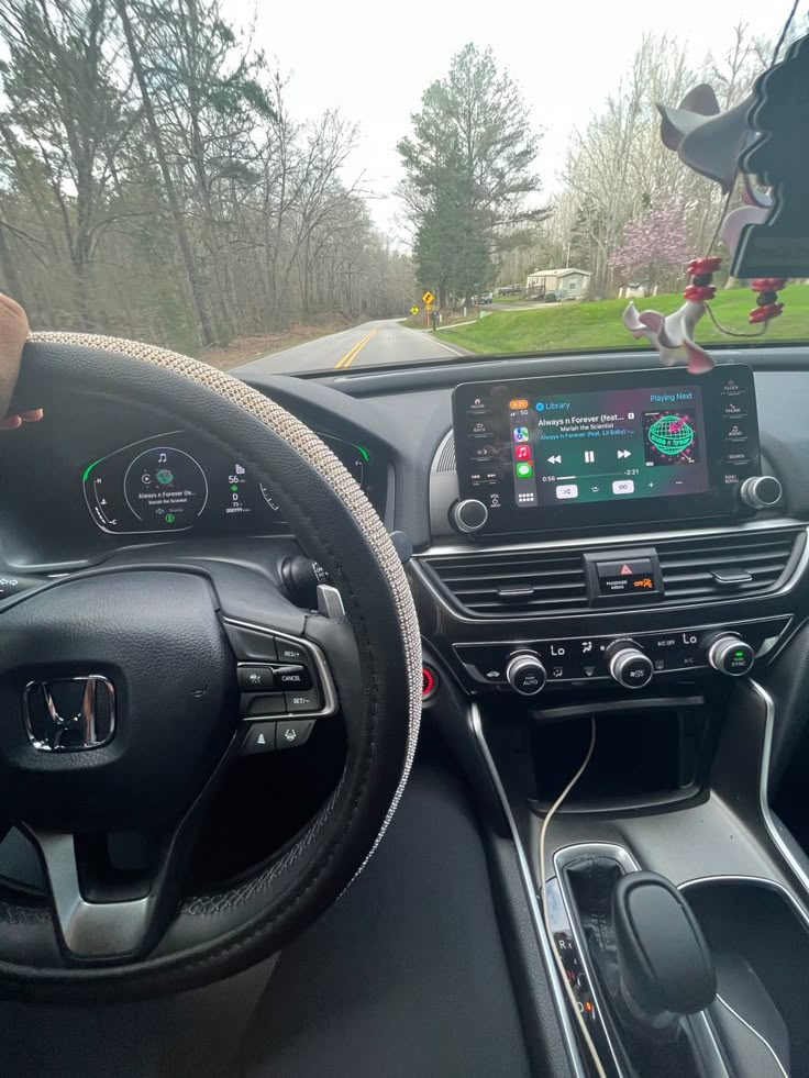 the interior of a car is shown with an electronic display and steering wheel, as well as dashboard controls