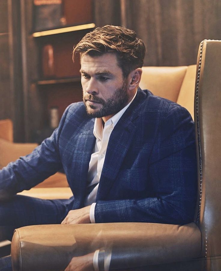 a man sitting in a chair wearing a suit and tie