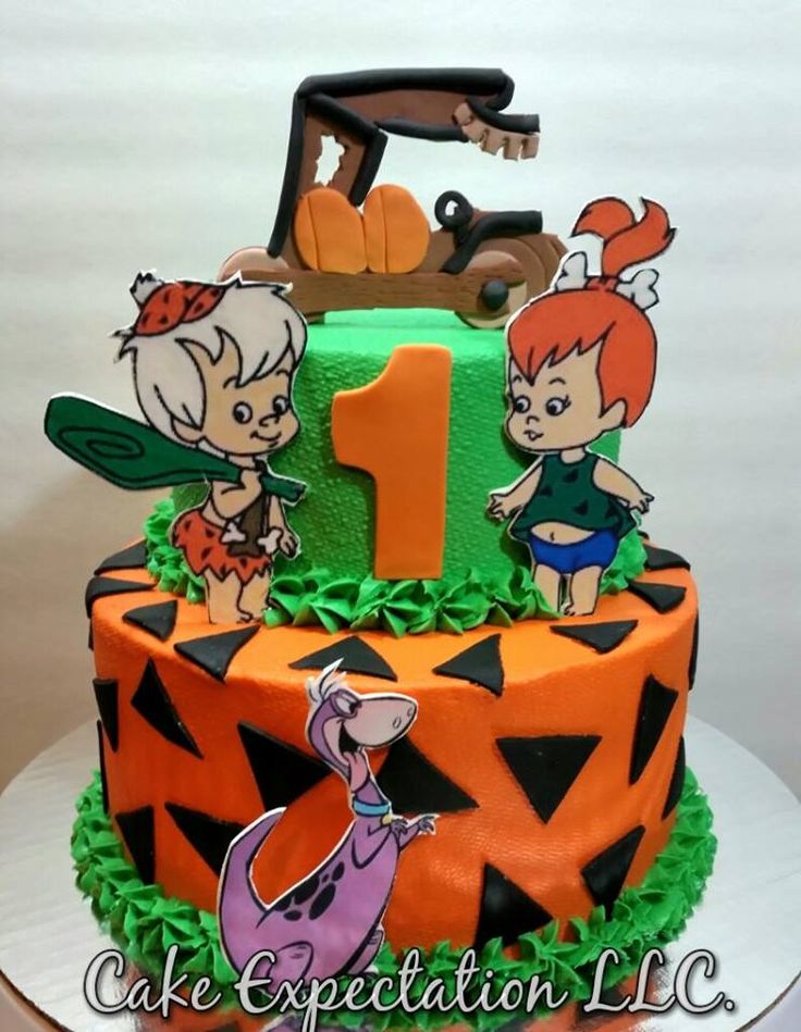 a birthday cake decorated with cartoon characters on it's top and the number one