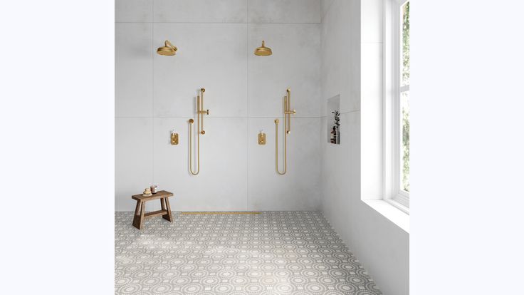 a white and gold bathroom with two shower heads on either side of the bathtub