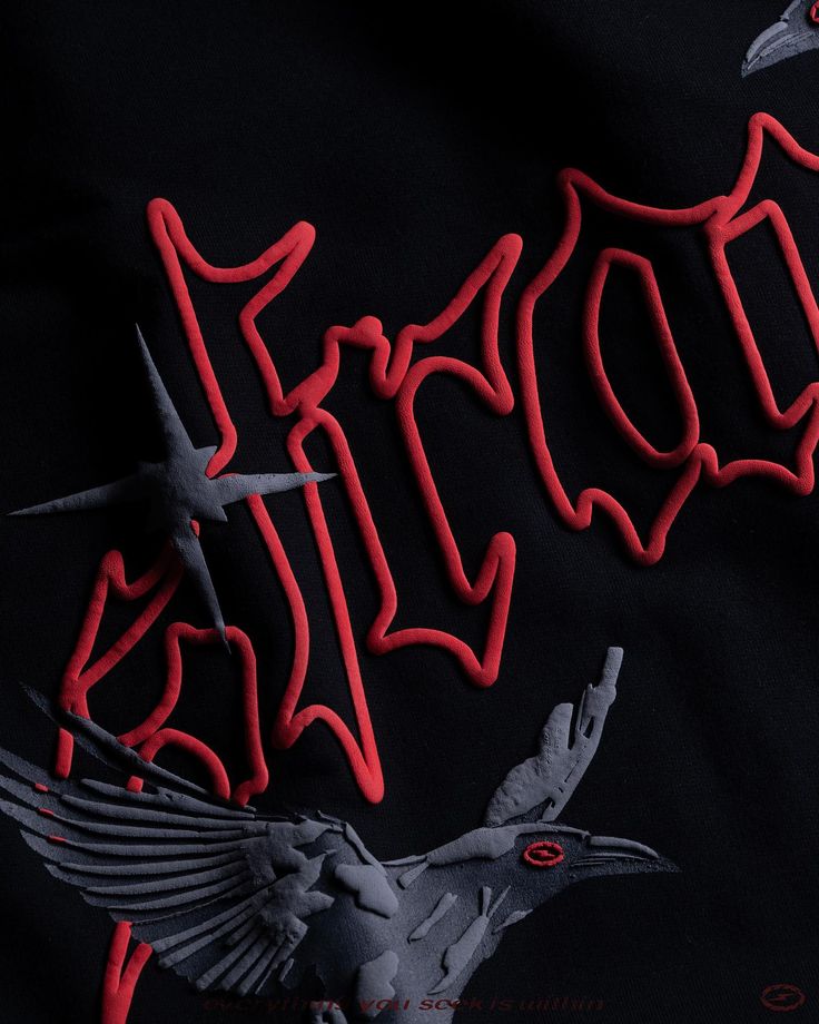 a black t - shirt with red lettering on the chest and an image of a bird