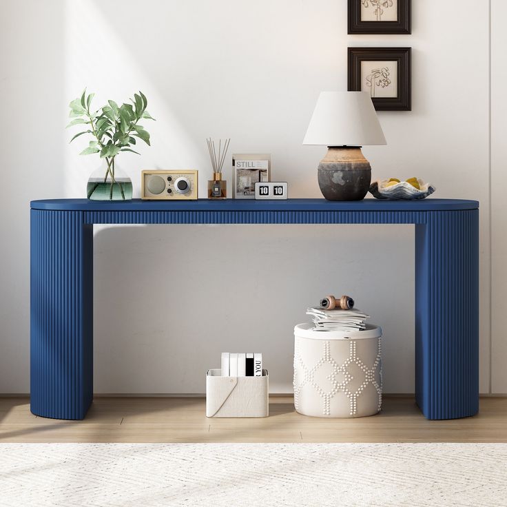 a blue console table sitting on top of a hard wood floor next to a lamp