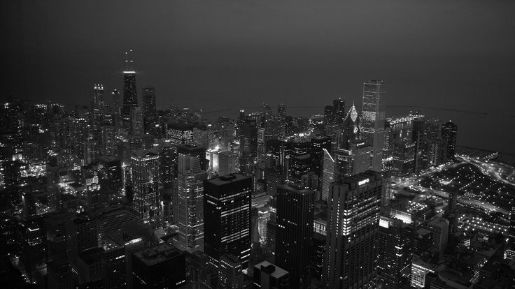 an aerial view of the city at night with skyscrapers lit up in black and white