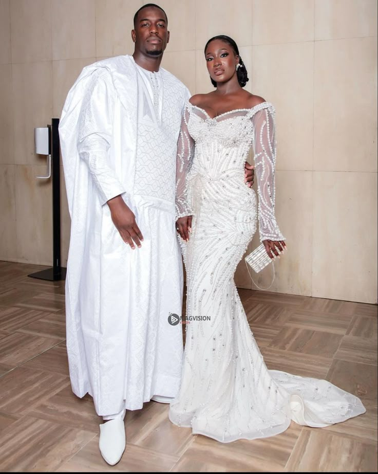 a man and woman dressed in white standing next to each other