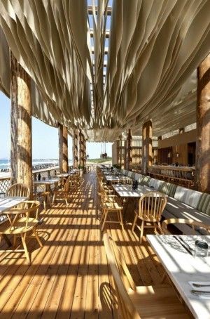 an outdoor dining area with wooden tables and chairs