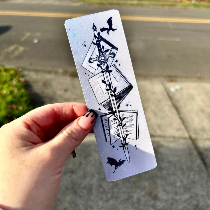 a person holding up a piece of paper with drawings on it