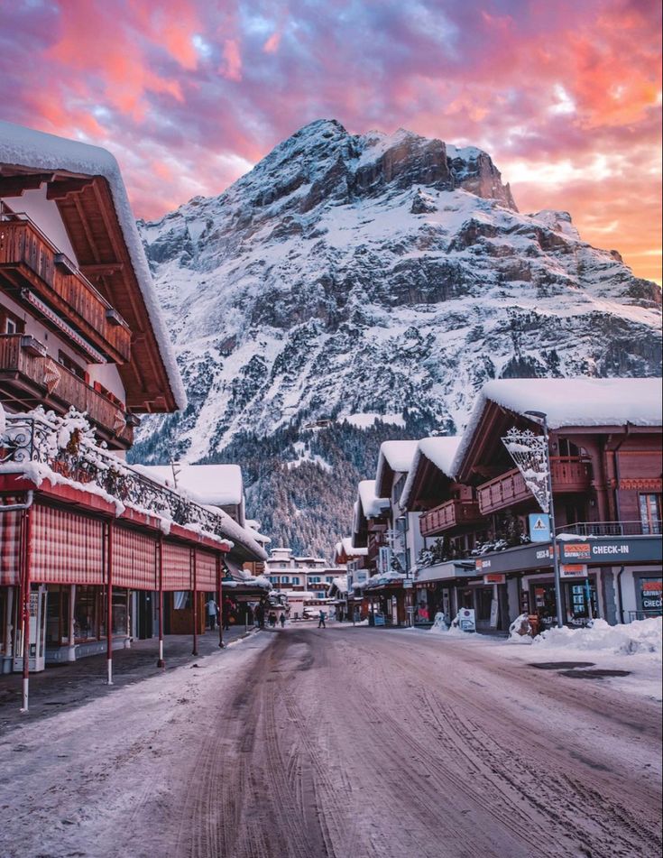 a snowy mountain is in the distance with buildings on either side