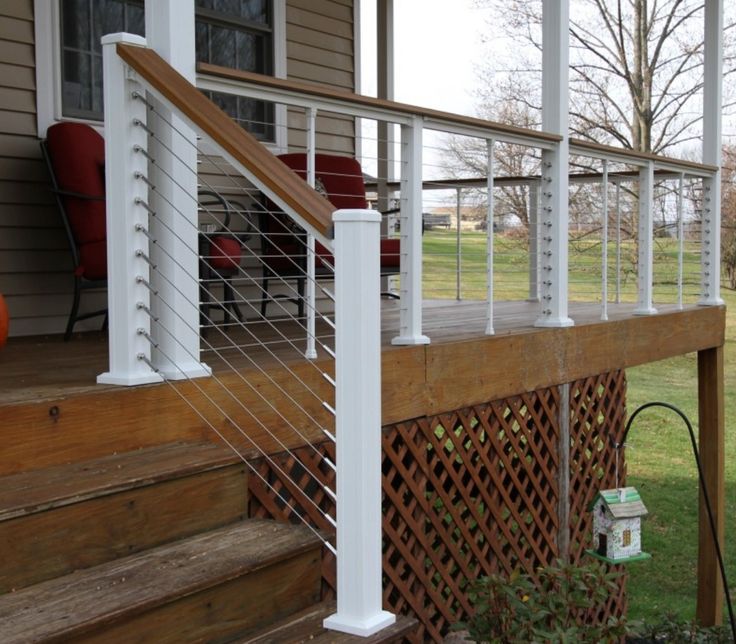 a porch with white railing and wooden steps