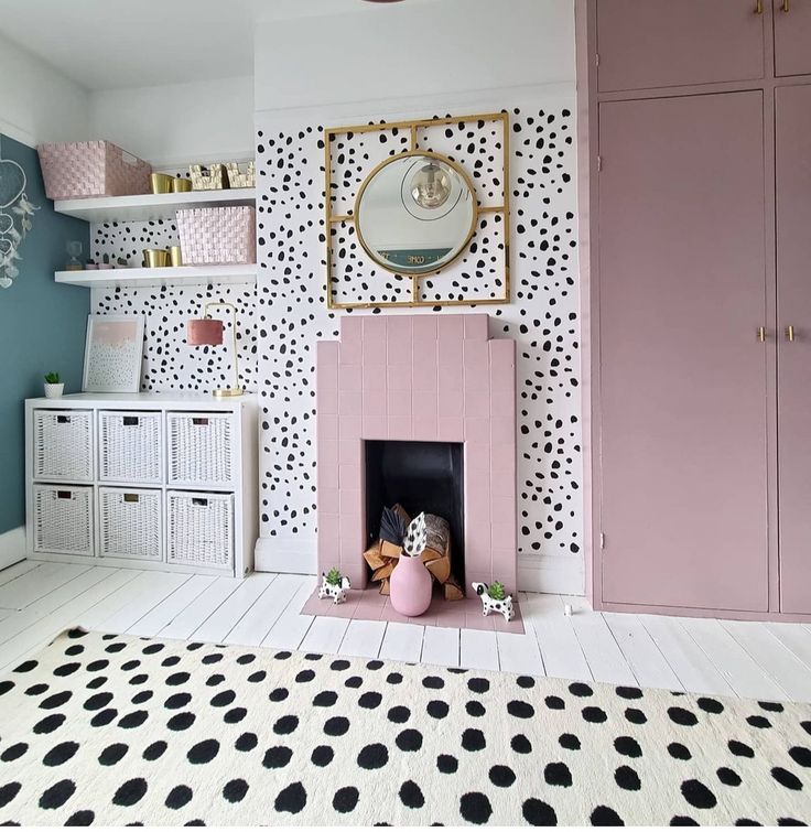 a living room with polka dot wallpaper and pink furniture in the corner, along with black and white flooring