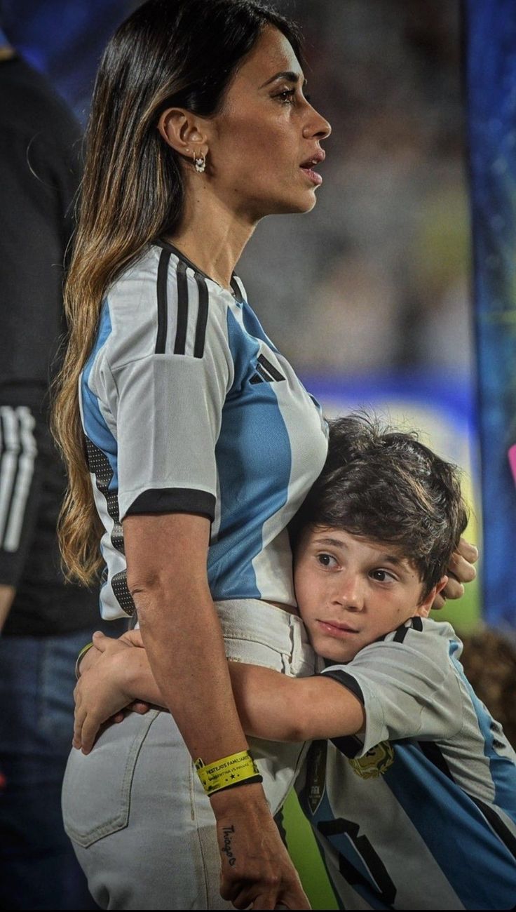 a woman holding a young boy in her arms