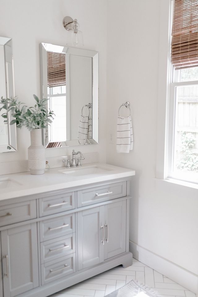 a white bathroom with two sinks and mirrors