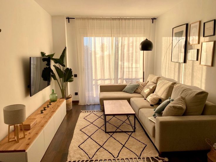 a living room filled with furniture and a flat screen tv on top of a wall