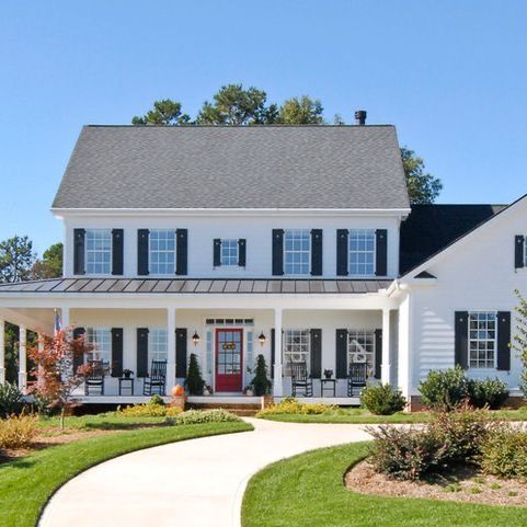 an image of a house with windows and shutters on the front, and landscaping in the back