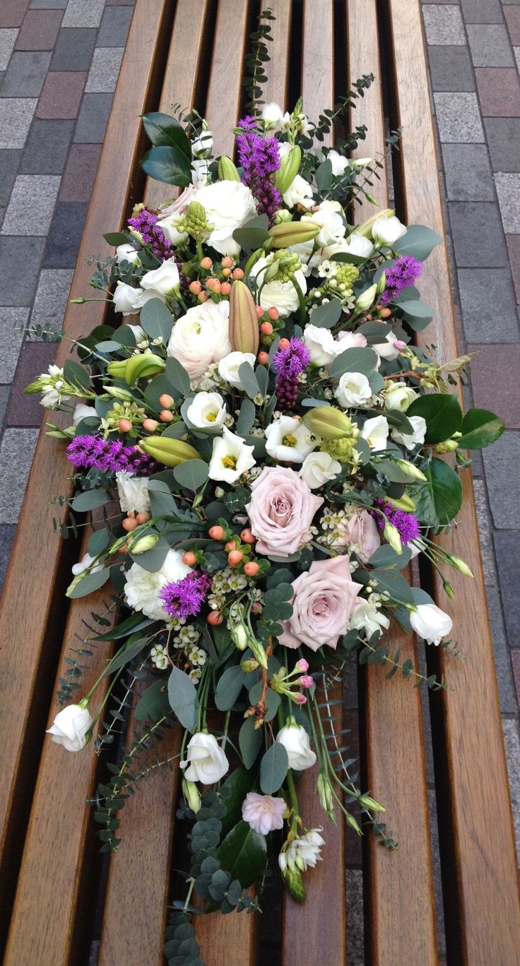 a bouquet of flowers sitting on top of a wooden bench