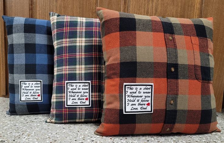 three different plaid pillows sitting on top of a counter next to each other, one has a button down closure and the other has a label that says i love you