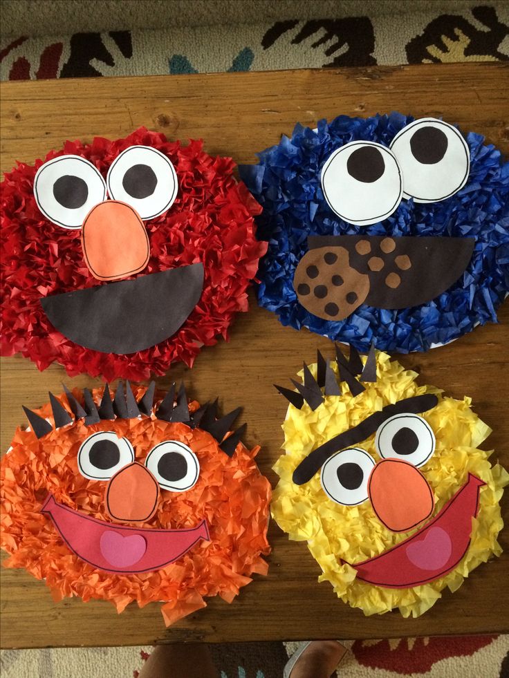 four cupcakes decorated to look like sesame street characters