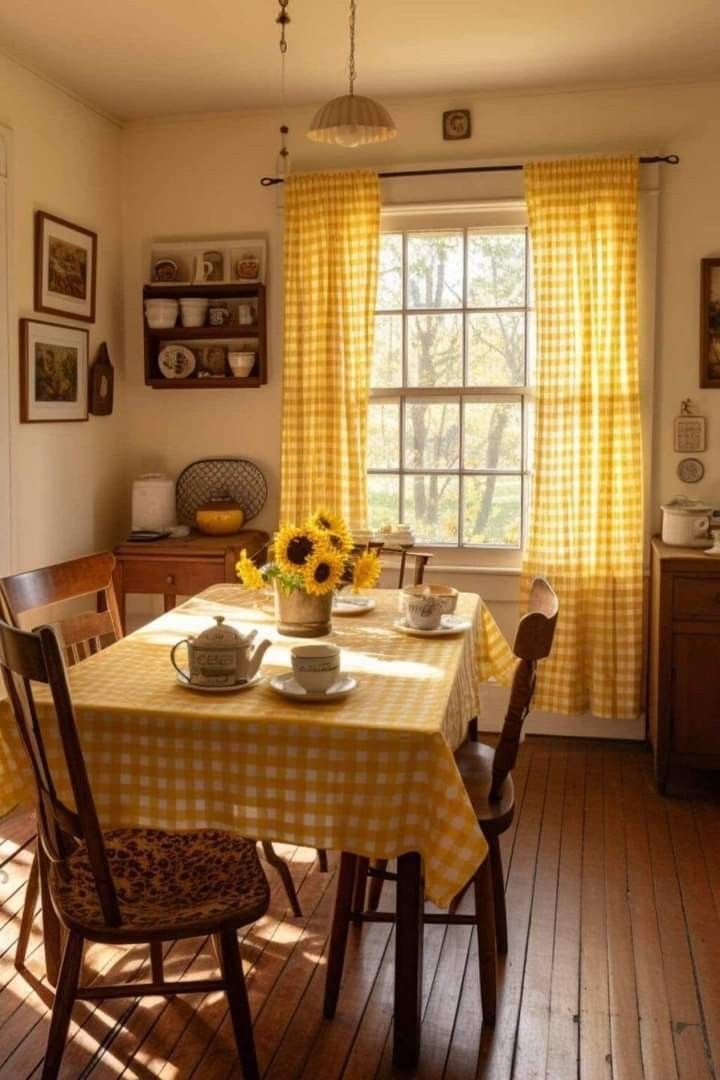 a dining room with yellow curtains and sunflowers on the table