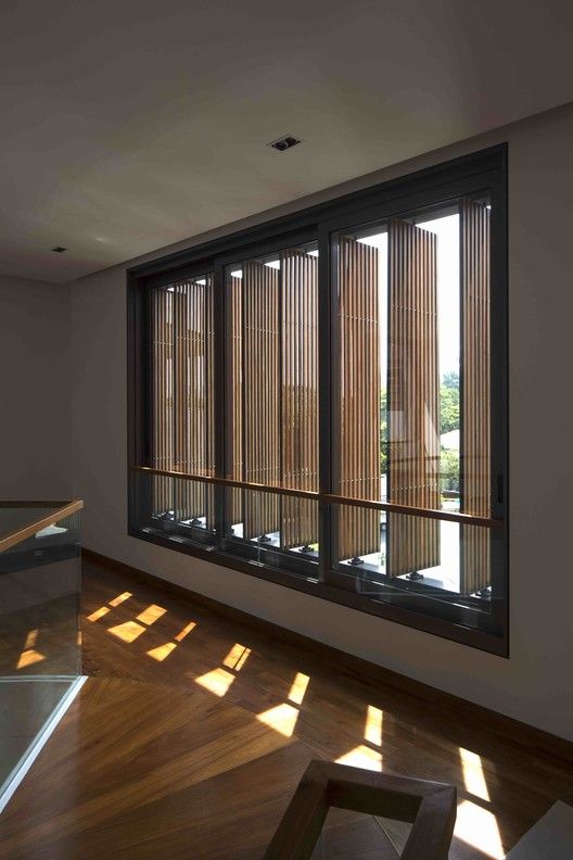 an empty room with wooden blinds on the windows and wood flooring in front of it