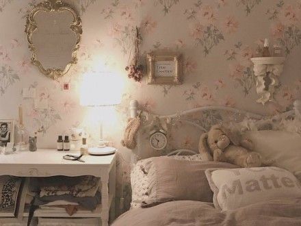 a bedroom with floral wallpaper and teddy bear sitting on the bed in front of it