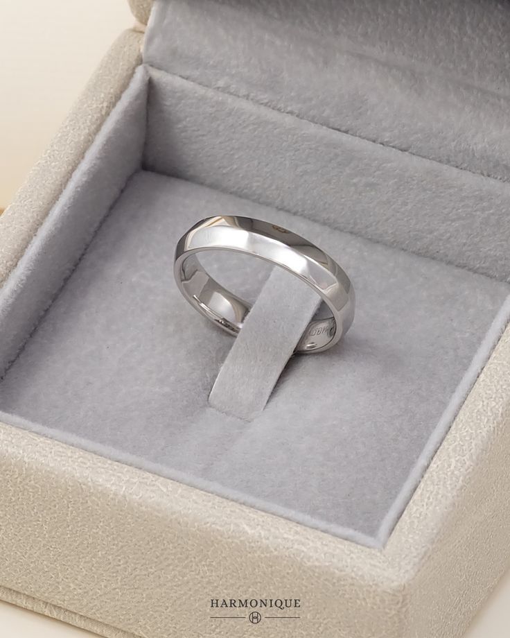 an open box with a silver ring in it