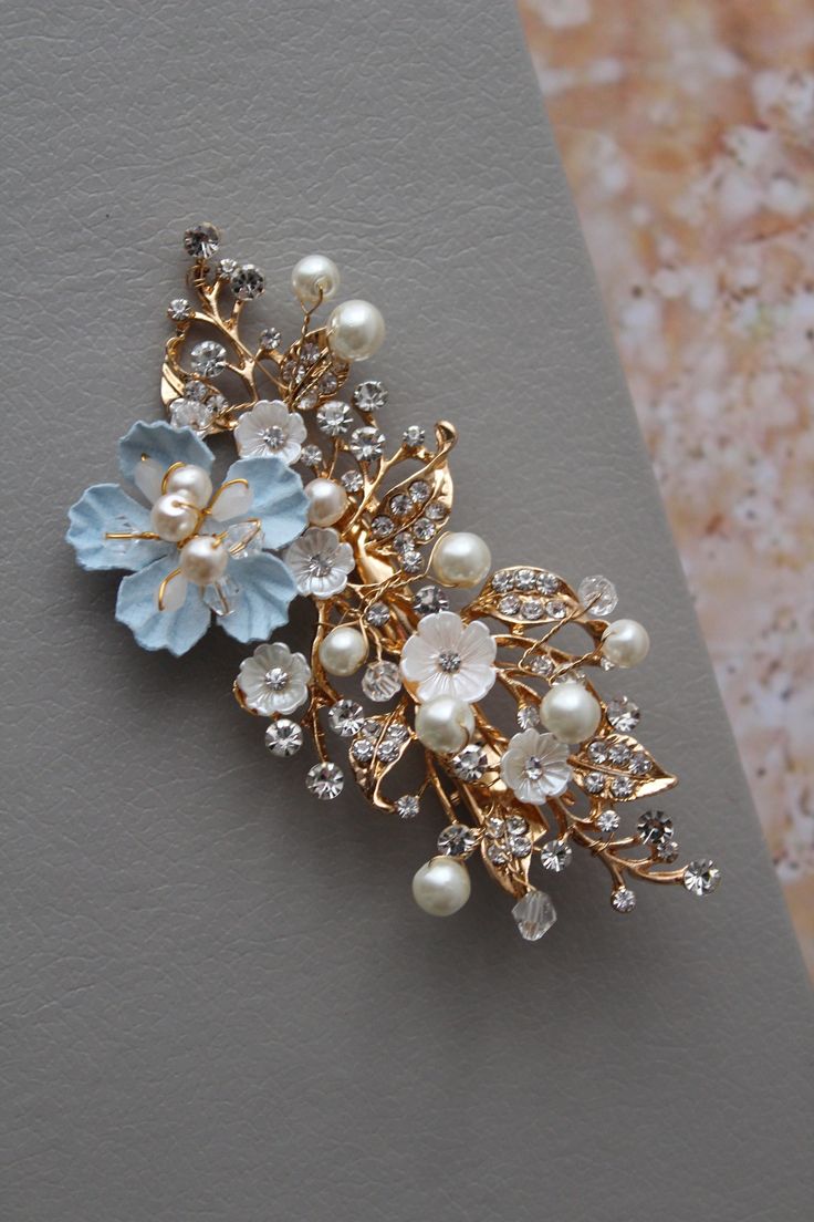 Small bridal hair clip  wedding hair piece Prom hair Colour: champagne  gold  tone/clear/ivory/lt. blue. Size approx 3.5 inches, width approx 1.5 inches. Materials: metal findings, faux pearls, beads, lt.blue paper flower, small lucite flowers, wire, alligator clip. This listing for one hair clip (similar blue headpieces available in other listings) SIMPLE PACKAGING. MORE SOMETHING BLUE (see last pictures): https://www.etsy.com/uk/shop/DonataleBridal?ref=seller-platform-mcnav&search_query=blue MORE hair accessories: https://www.etsy.com/uk/shop/DonataleBridal?ref=seller-platform-mcnav&search_query=hair Wedding JEWELRY: https://www.etsy.com/uk/shop/DonataleBridal?ref=seller-platform-mcnav&section_id=19125584 Wedding SASHES: https://www.etsy.com/uk/shop/DonataleBridal?ref=seller-platform-mcn Blue Flower Wedding, Wedding Flower Hair Pieces, Flower Wedding Hair, Hair Piece Wedding Hair, Bridesmaid Hair Comb, Wedding Hair Clip, Floral Hair Comb, Hair Piece Wedding, Something Blue Bridal