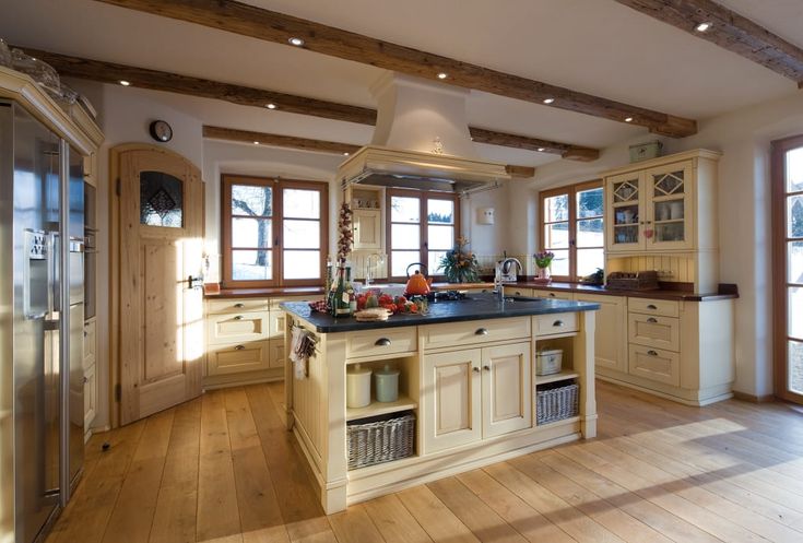 a large kitchen with wooden floors and white cabinets